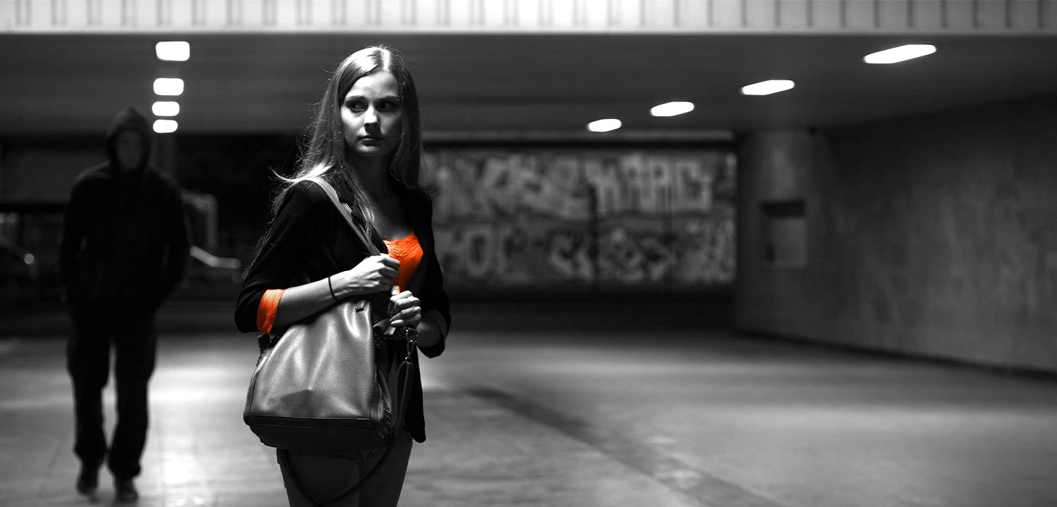 Frau bewegt sich aufmerksam durch eine Unterführung und steht für Aufmerksamkeit, Selbstschutz und einen bewussten Umgang mit potenziellen Gefahrensituationen.