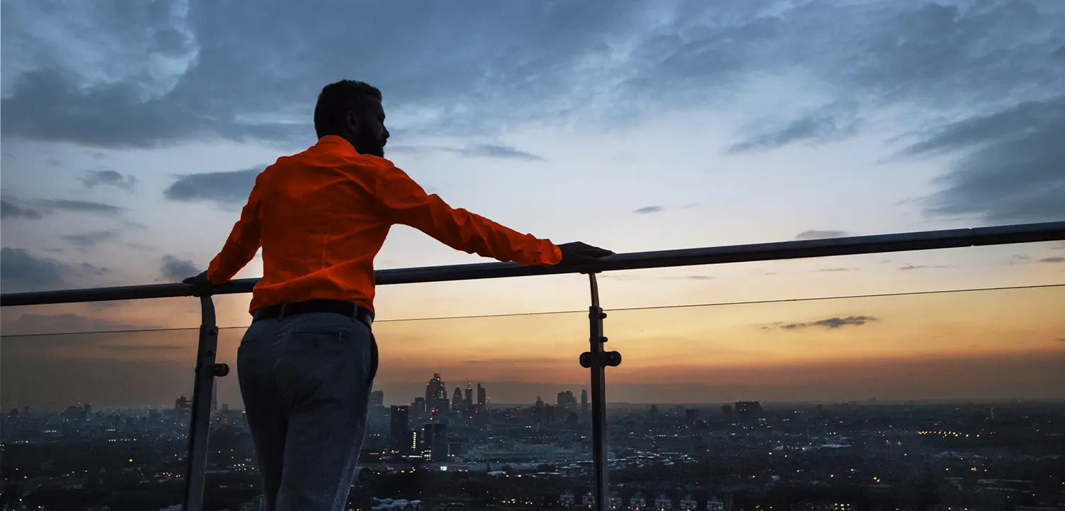 Person blickt entschlossen über die Skyline und symbolisiert emotionale Stärke, mentale Klarheit und persönliche Entwicklung.